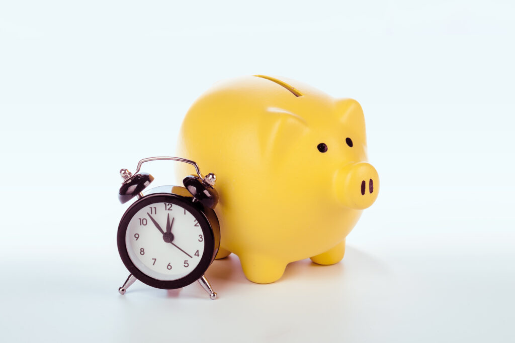 piggy bank and alarm clock symbolizing saving time and money with preventive dental care at Dental Professionals of Dardenne in Dardenne Prairie, MO